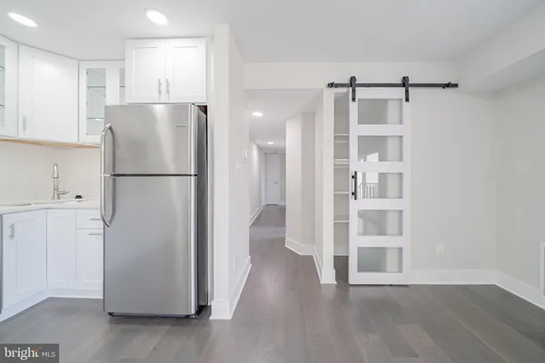 a view of kitchen with refrigerator cabinets and wooden floor