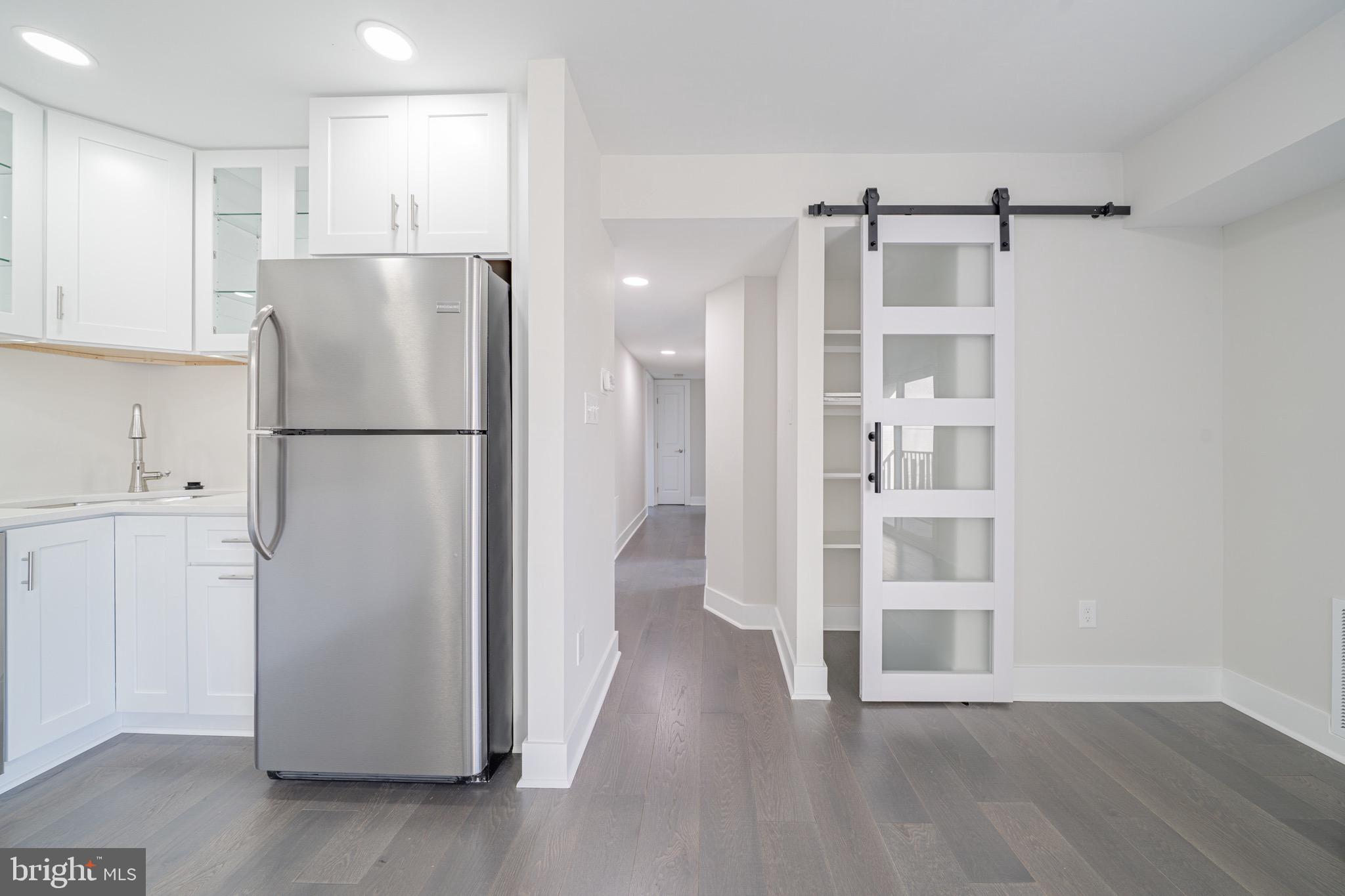3122 Brinkley Road, Unit 102 Temple Hills, MD 20748 - Photo 18 of 44 a view of kitchen with refrigerator cabinets and wooden floor