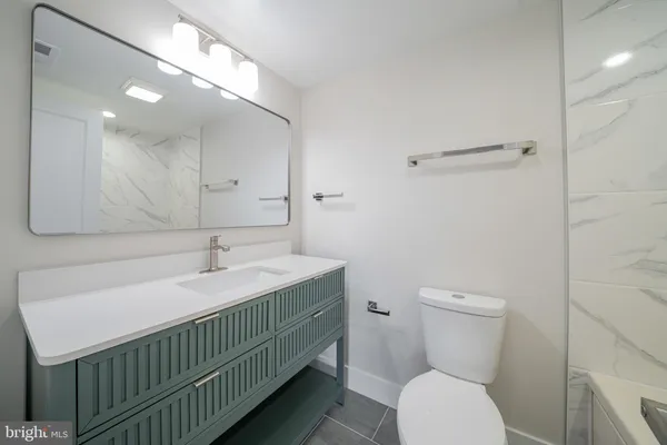 a bathroom with a sink a toilet and mirror