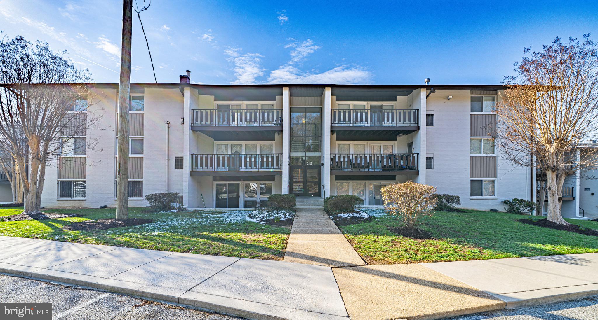 3122 Brinkley Road, Unit 102 Temple Hills, MD 20748 - Photo 2 of 44 a front view of a building with a garden and plants