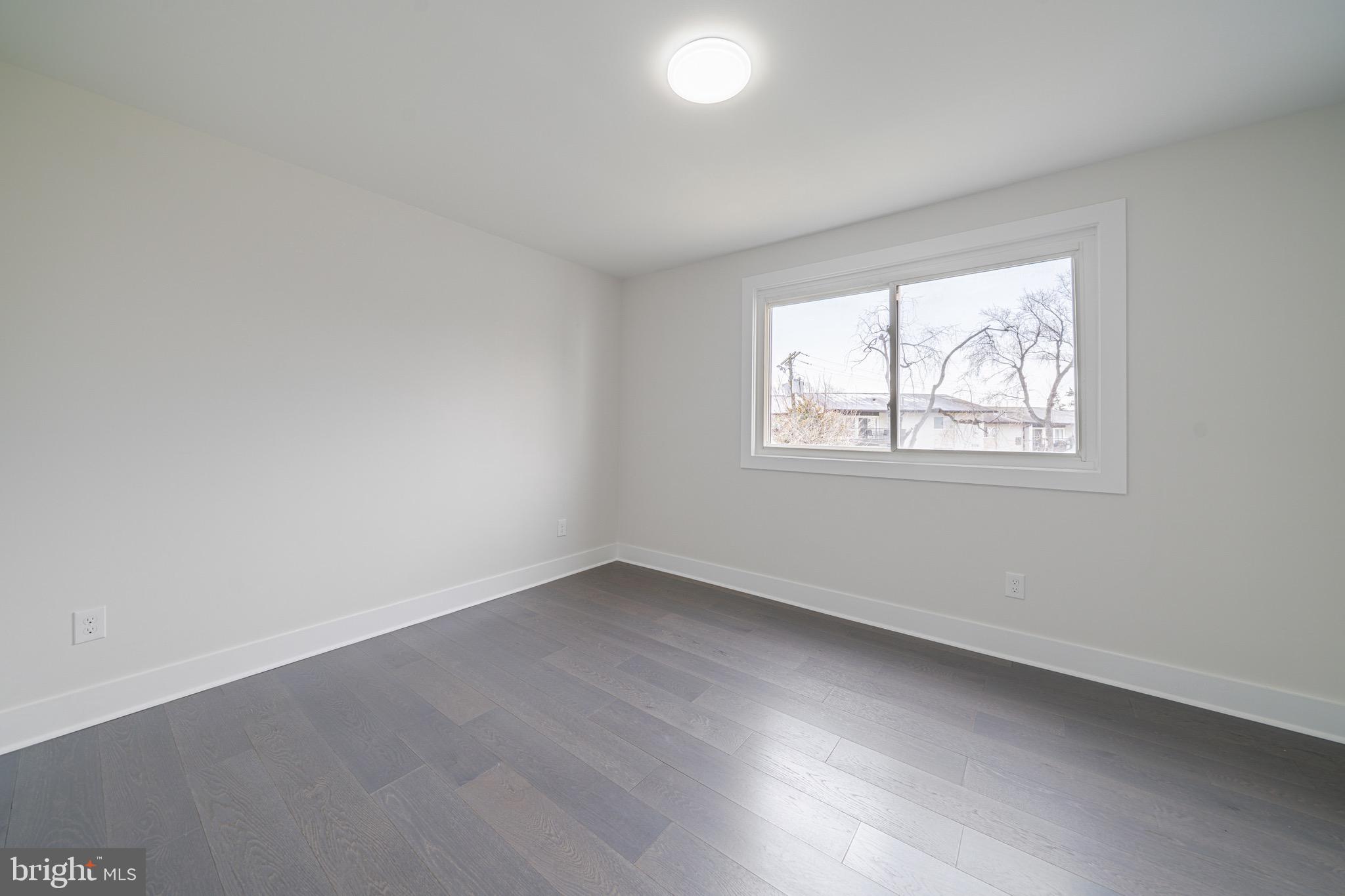 3122 Brinkley Road, Unit 102 Temple Hills, MD 20748 - Photo 22 of 44 an empty room with wooden floor and windows