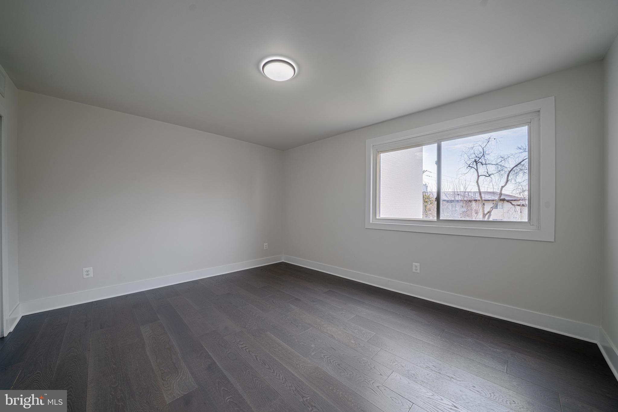 3122 Brinkley Road, Unit 102 Temple Hills, MD 20748 - Photo 25 of 44 a view of an empty room with wooden floor and a window