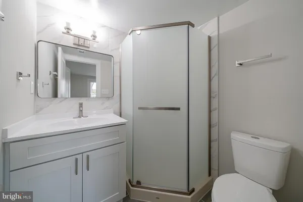a bathroom with a toilet sink vanity and mirror