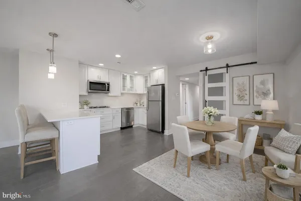 a living room with stainless steel appliances kitchen island granite countertop furniture and a dining table with kitchen view