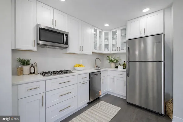 a kitchen with white cabinets and stainless steel appliances