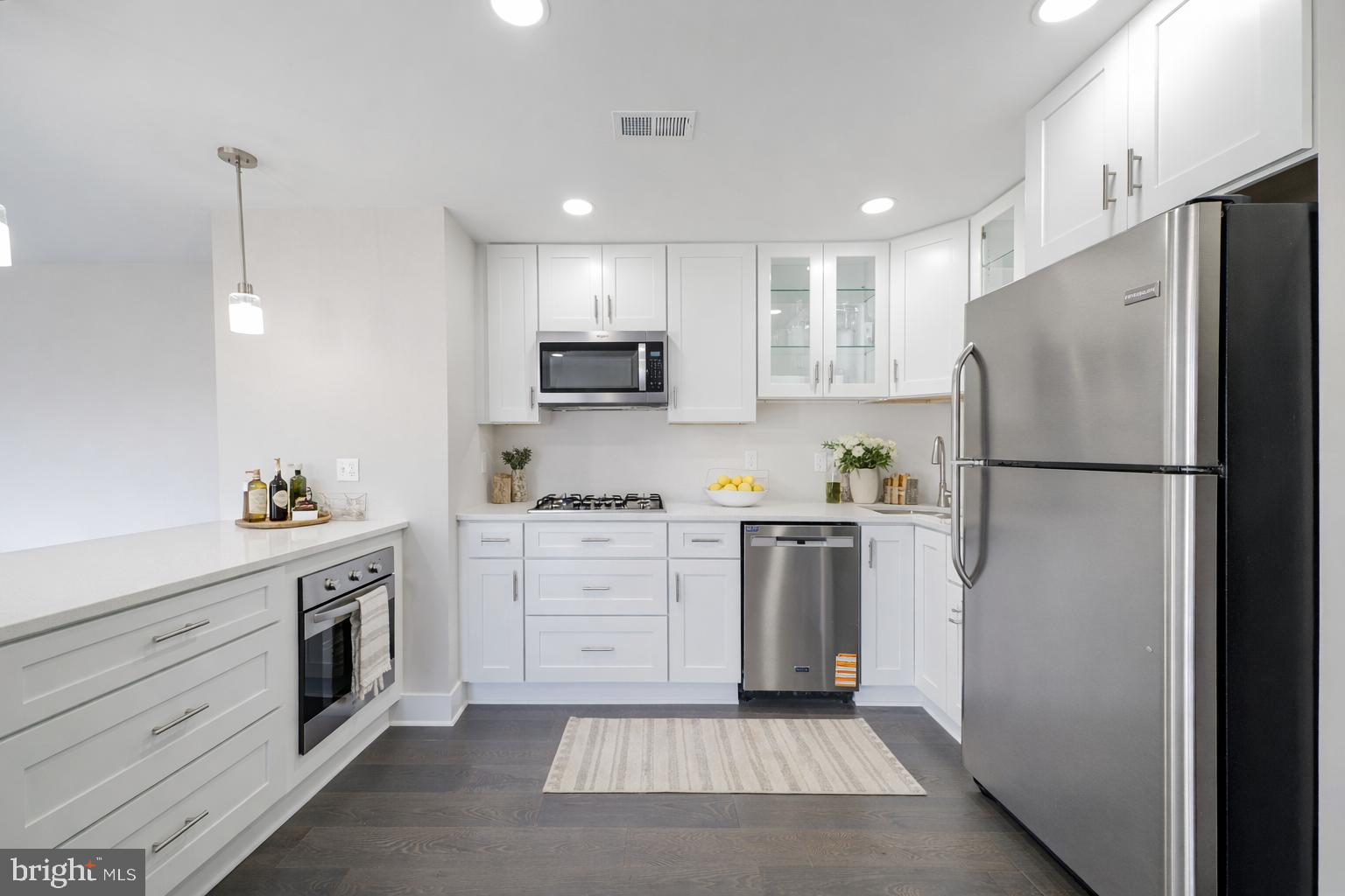 3122 Brinkley Road, Unit 102 Temple Hills, MD 20748 - Photo 42 of 44 a kitchen with white cabinets and stainless steel appliances