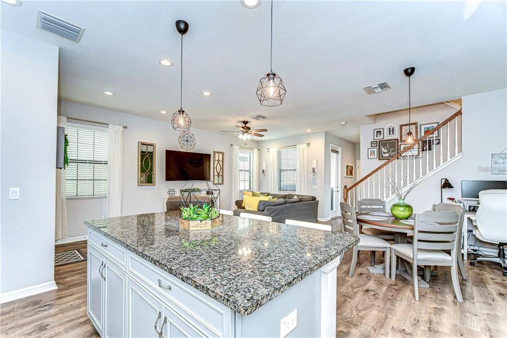 5703 Colony Glen Road Lithia, FL 33547 - Photo 12 of 56 a kitchen with granite countertop a stove a sink a dining table and chairs
