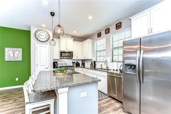 a kitchen with granite countertop stainless steel appliances a counter space and refrigerator