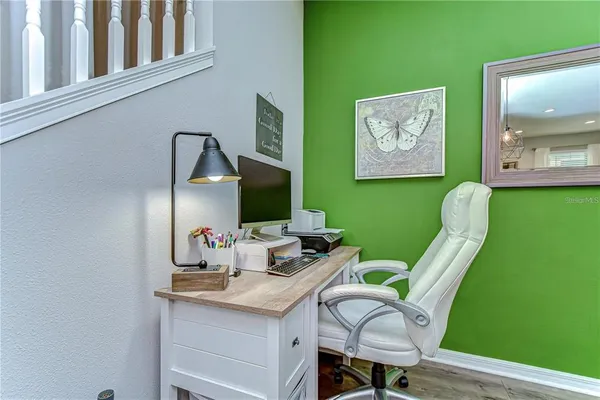 a view of a workspace with furniture and a window