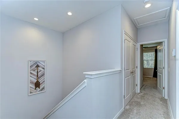 a view of a hallway with closet and bathroom
