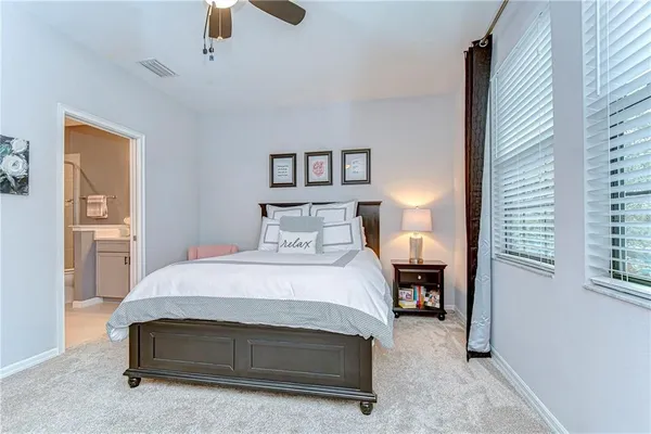 a spacious bedroom with a bed and a chandelier