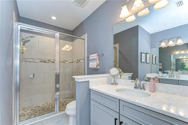 a en suite bathroom with a double vanity sink and a mirror