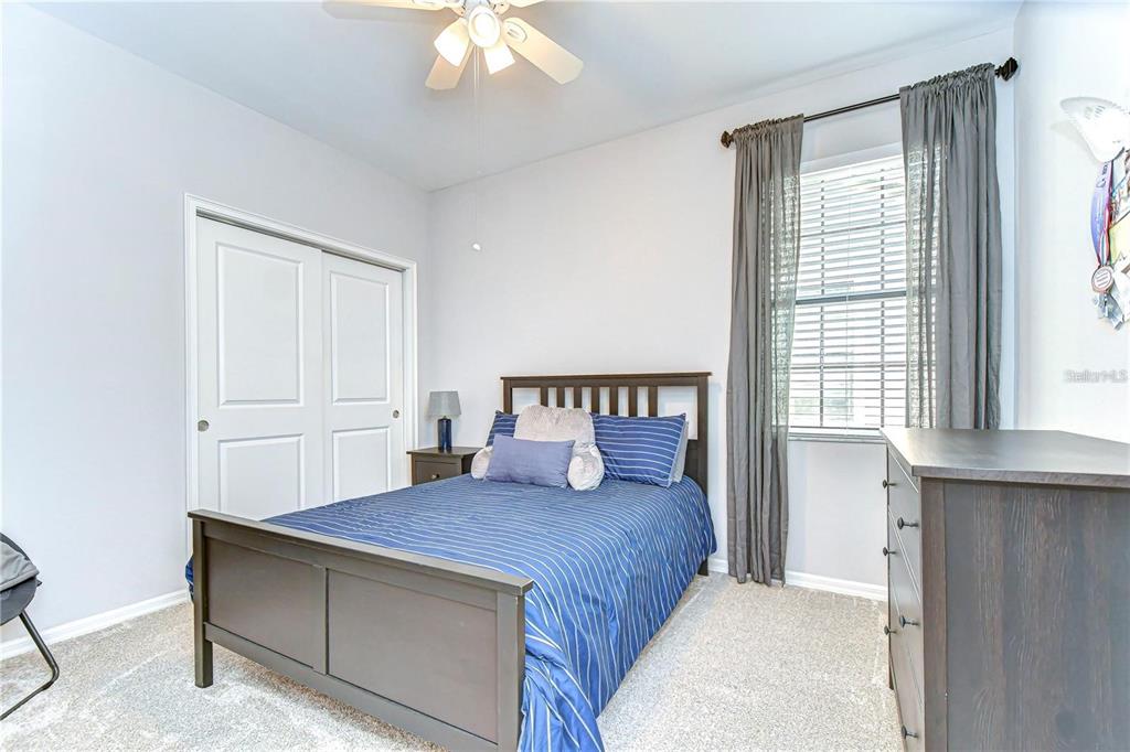 5703 Colony Glen Road Lithia, FL 33547 - Photo 37 of 56 a bedroom with a large bed and a chandelier