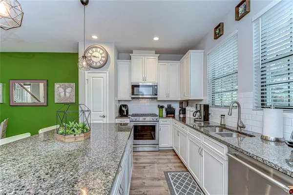 a kitchen with cabinets a window and stainless steel appliances