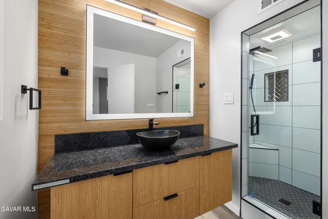 a bathroom with a granite countertop sink a toilet and shower