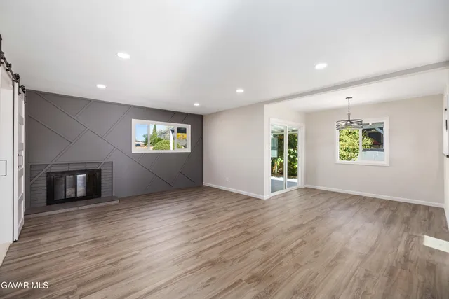 an empty room with windows and fireplace