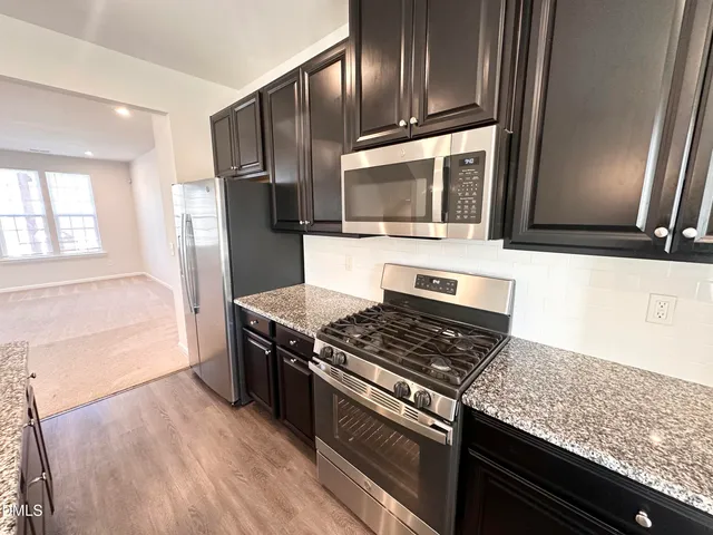 a kitchen with granite countertop stainless steel appliances and wooden cabinets