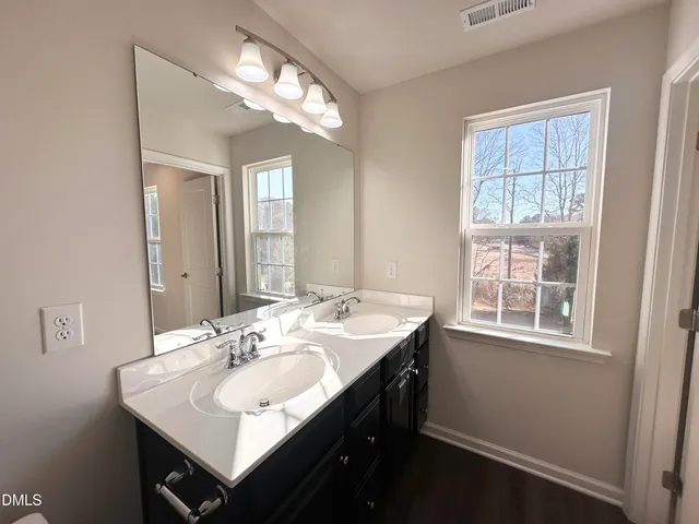 a bathroom with a sink double vanity and a mirror