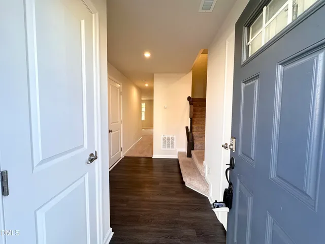 a view of a hallway with wooden floor and staircase