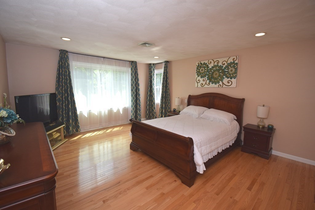 2 Mattakesett Circle Sharon, MA 02067 - Photo 19 of 40 a spacious bedroom with a bed and a flat tv screen on dresser