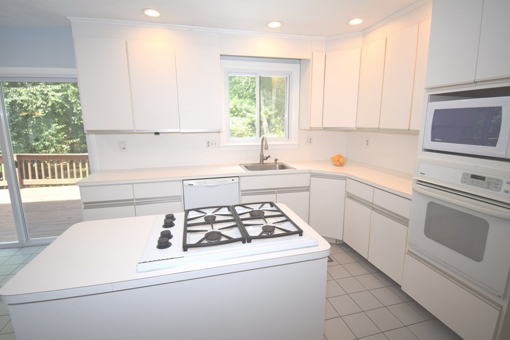 2 Mattakesett Circle Sharon, MA 02067 - Photo 6 of 40 a kitchen with sink a stove and white cabinets with wooden floor