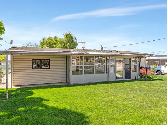 1502 North 475 West Sunset, UT 84015 - Photo 18 of 23 Expansive rear lawn featuring a sunroom addition with multiple windows and a storm door entry