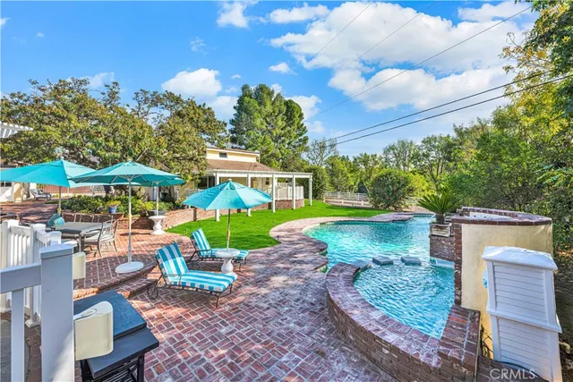 a view of a patio with a table and chairs under an umbrella