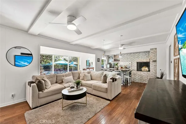 a view of a dining room and livingroom with furniture wooden floor a chandelier