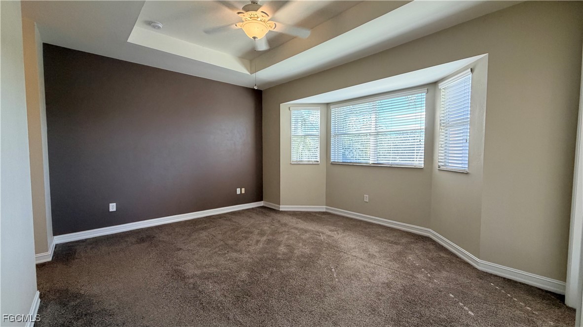 13071 Sandy Key Bend, Unit 304 North Fort Myers, FL 33903 - Photo 19 of 37 an empty room with a chandelier fan and windows