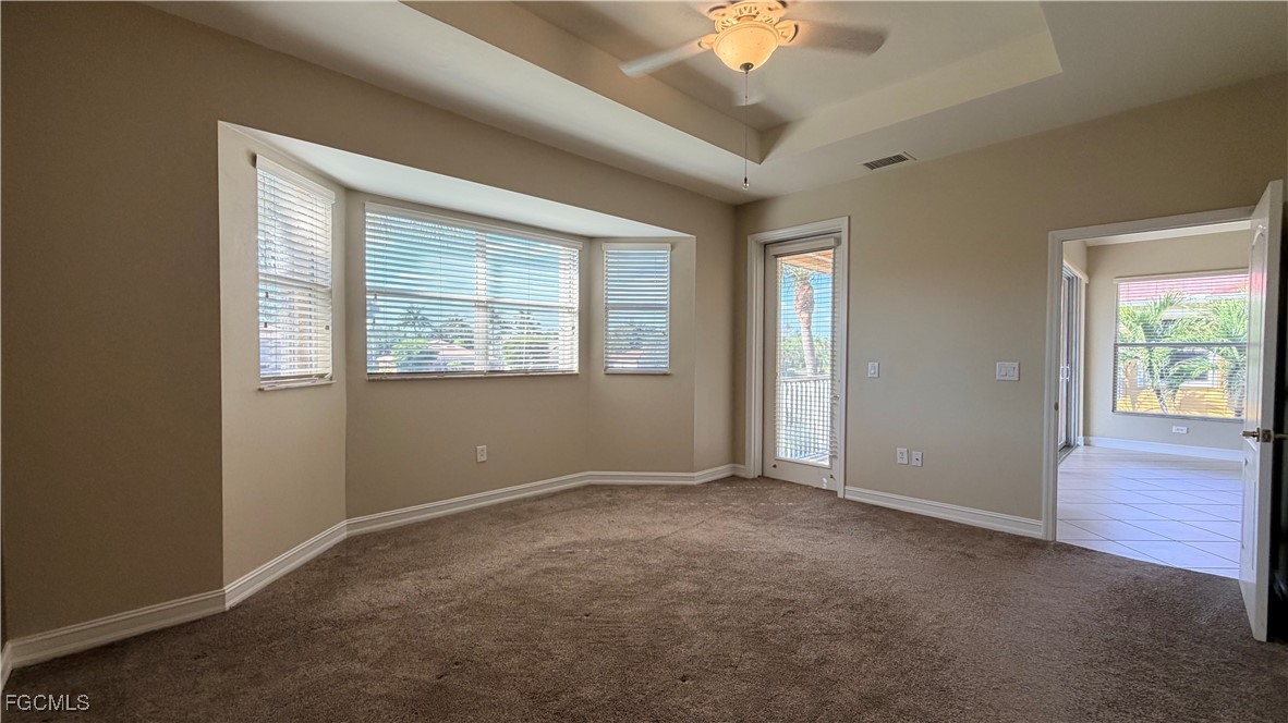 13071 Sandy Key Bend, Unit 304 North Fort Myers, FL 33903 - Photo 20 of 37 an empty room with a chandelier fan and windows