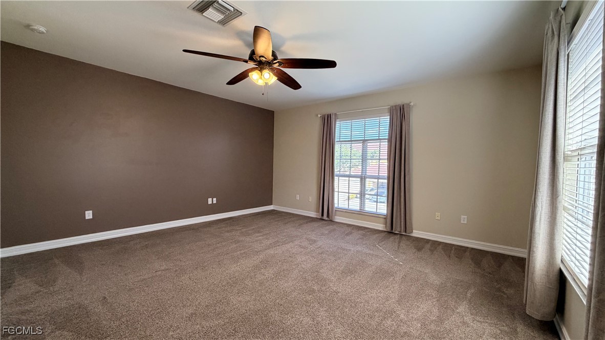13071 Sandy Key Bend, Unit 304 North Fort Myers, FL 33903 - Photo 27 of 37 an empty room with windows and fan