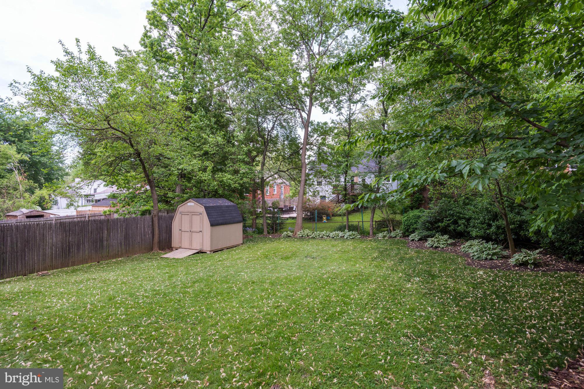 9109 Eton Road Silver Spring, MD 20901 - Photo 23 of 30 a view of a backyard with large trees and wooden fence