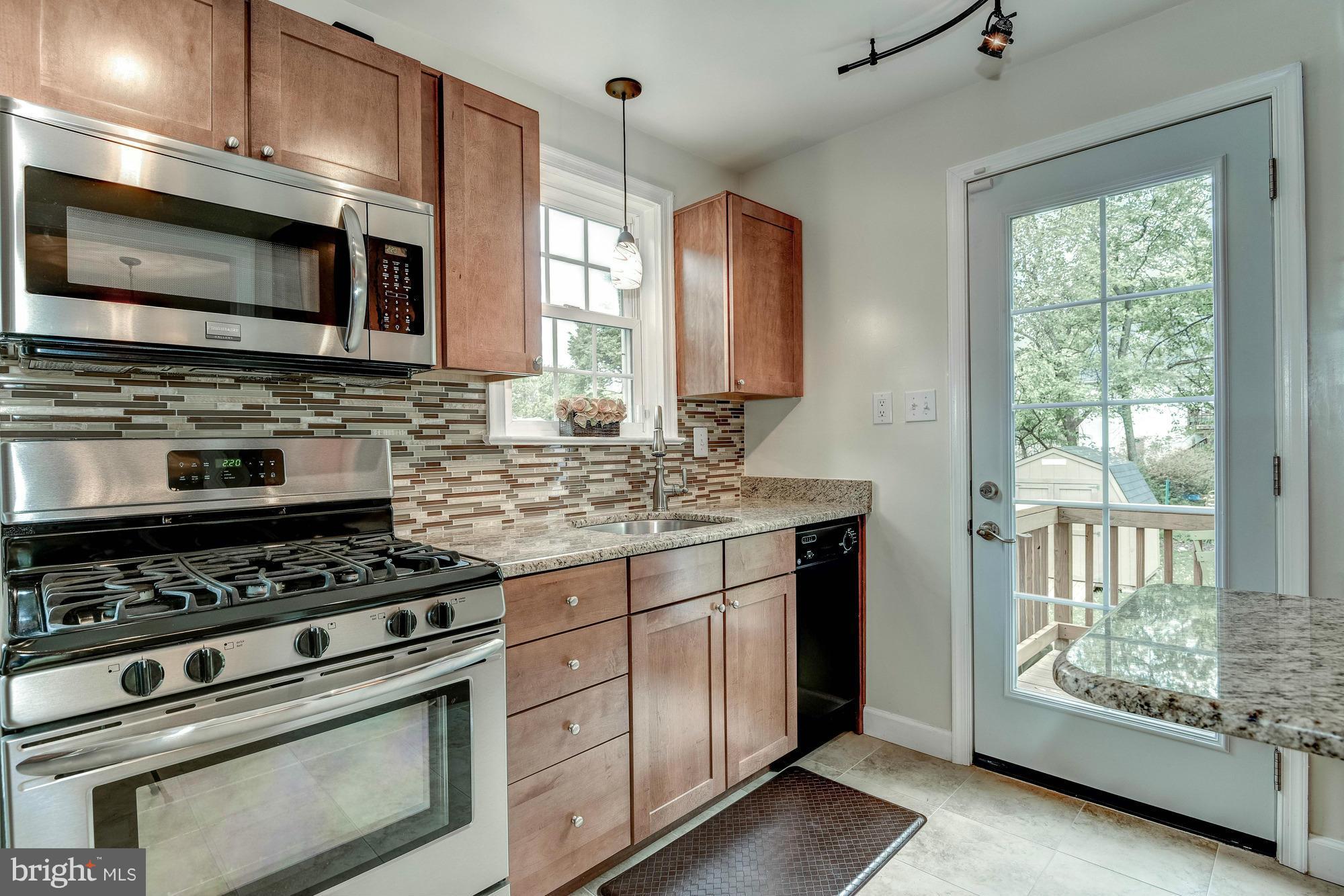9109 Eton Road Silver Spring, MD 20901 - Photo 7 of 30 a kitchen with stainless steel appliances granite countertop a stove and a microwave
