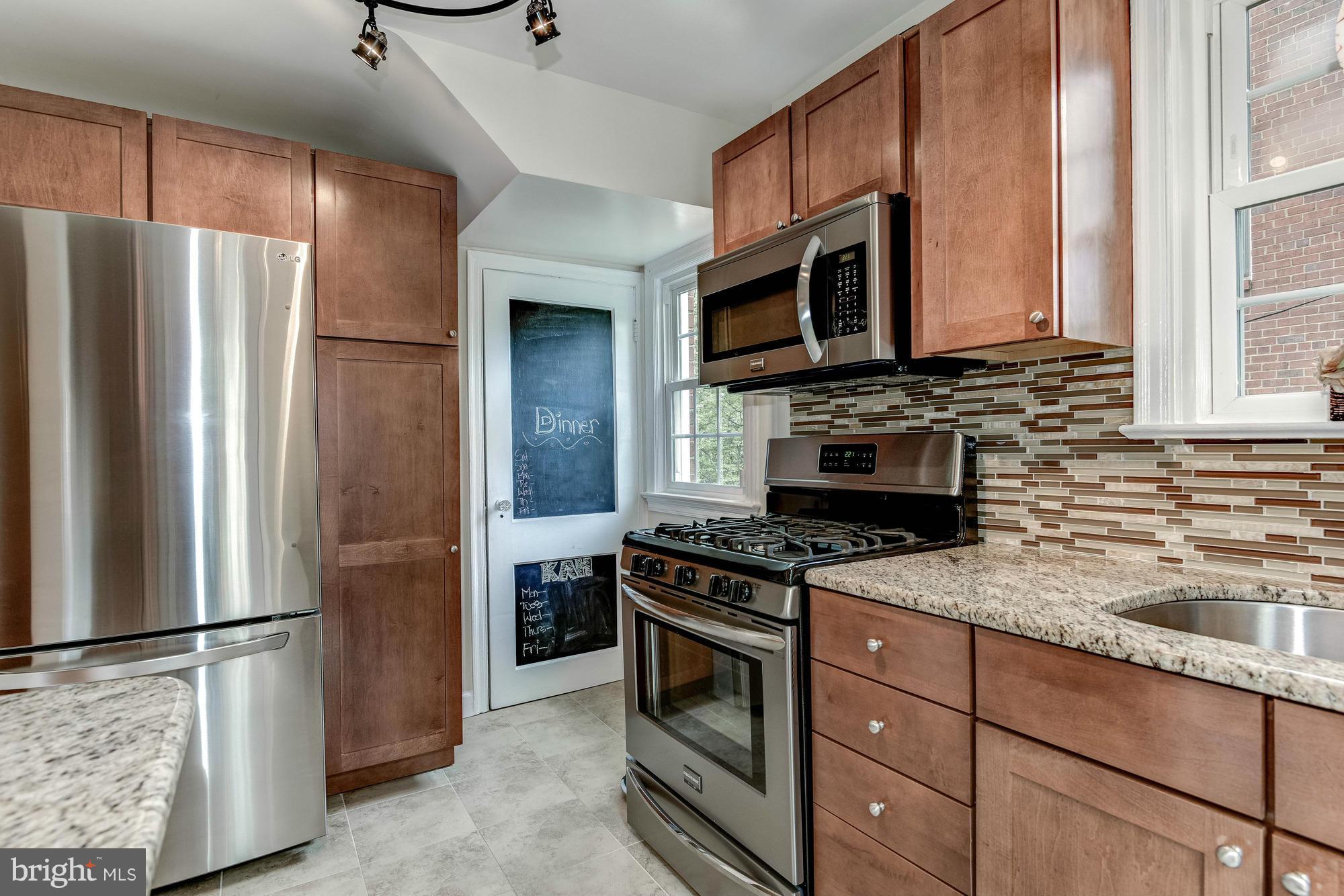 9109 Eton Road Silver Spring, MD 20901 - Photo 9 of 30 a kitchen with stainless steel appliances granite countertop a refrigerator stove and microwave