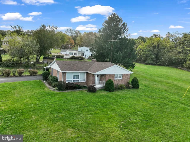 a aerial view of a house with yard and green space