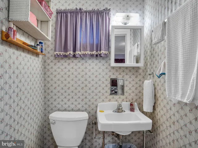a bathroom with a toilet sink and mirror