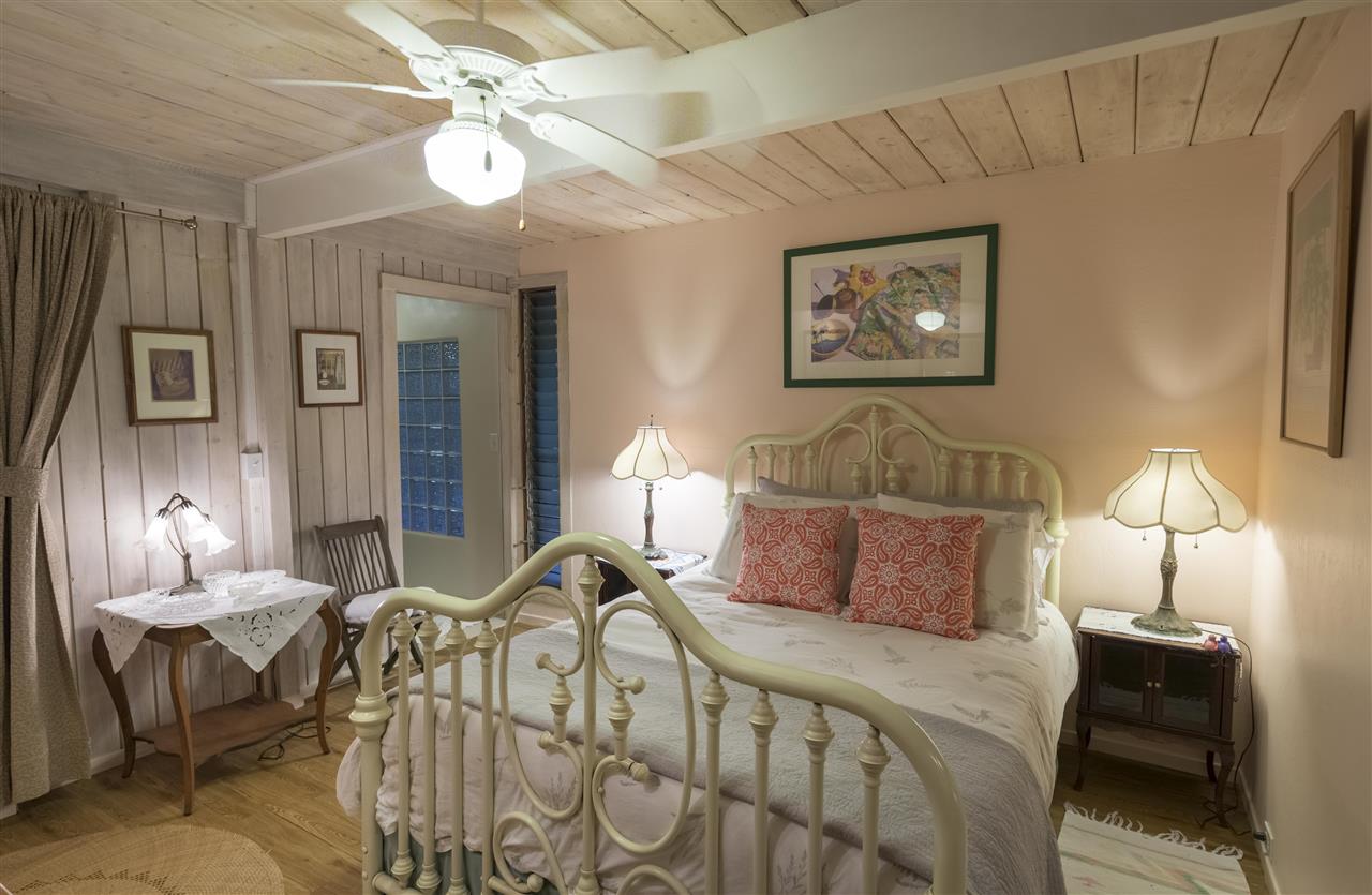 2555 Lemi Place Haiku, HI 96708 - Photo 19 of 30 a bedroom with a bed and a chandelier