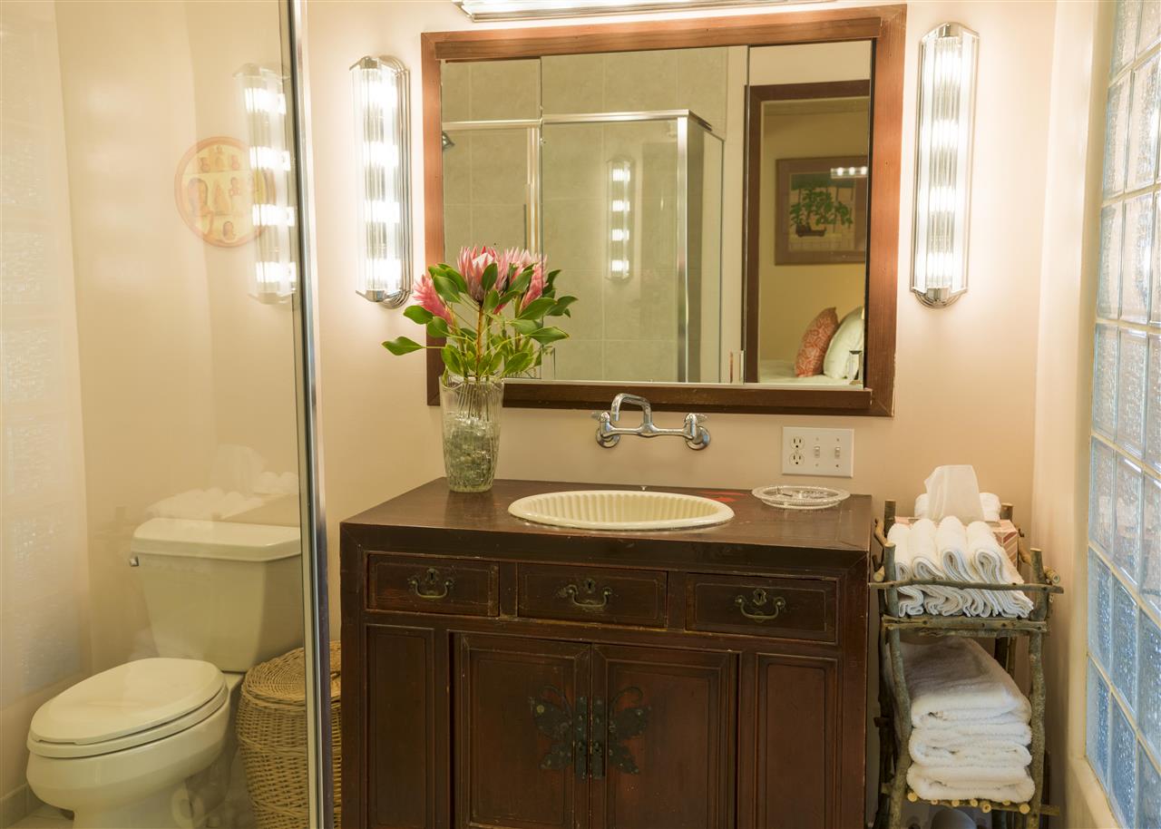 2555 Lemi Place Haiku, HI 96708 - Photo 20 of 30 a bathroom with a granite countertop sink a toilet and a mirror