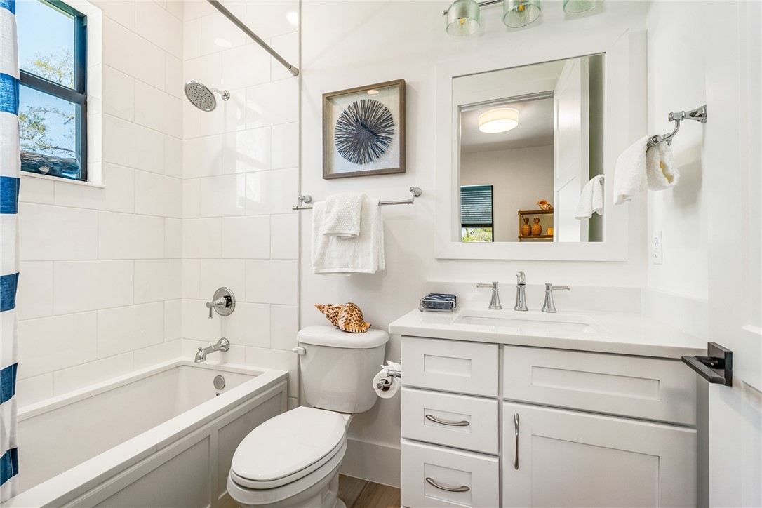 636 Cypress Road Vero Beach, FL 32963 - Photo 24 of 32 a bathroom with a toilet a sink a mirror a bathtub and vanity