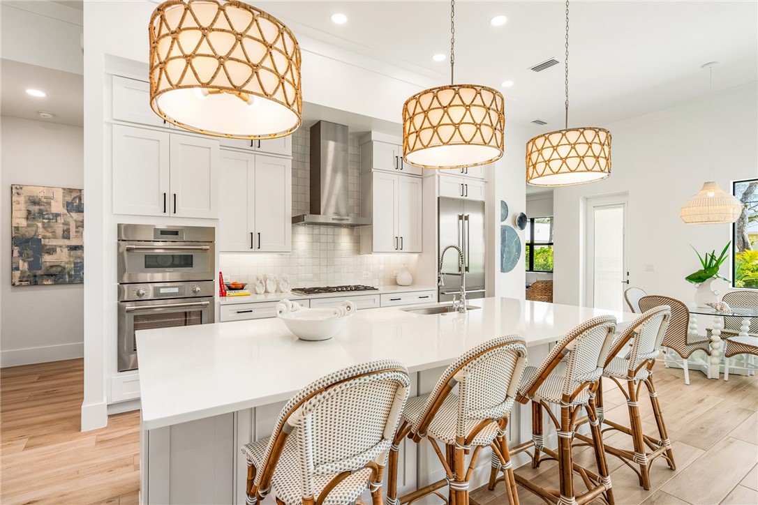 636 Cypress Road Vero Beach, FL 32963 - Photo 9 of 32 a kitchen with stainless steel appliances a table chairs and chandelier