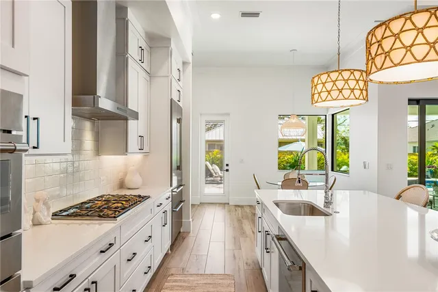 a kitchen with stainless steel appliances granite countertop a sink stove and refrigerator