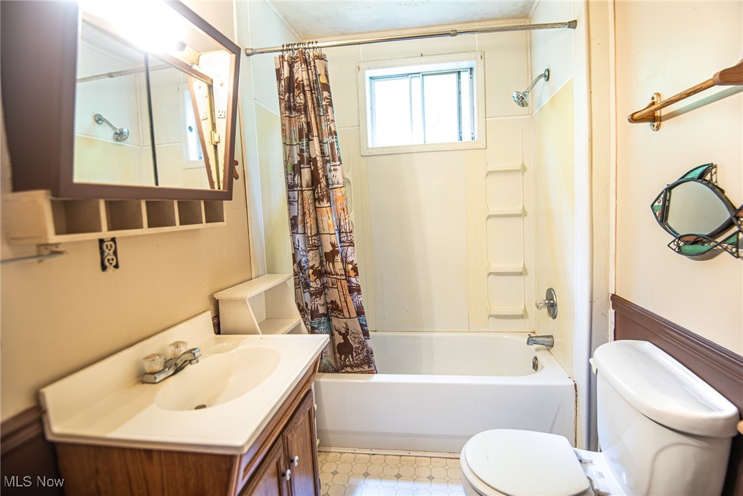 78911 Hamilton Ridge Road Freeport, OH 43973 - Photo 9 of 15 Full bathroom featuring tile patterned flooring, vanity, shower / tub combo with curtain, and toilet