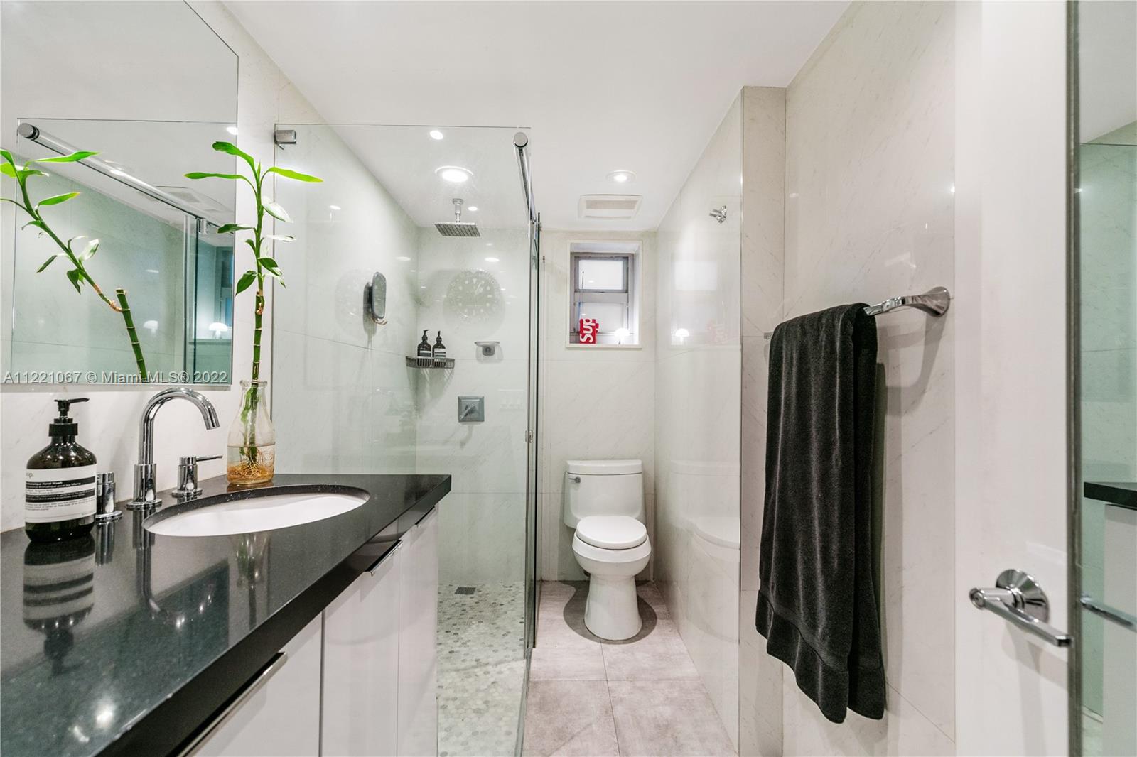 1674 Bay Road, Unit 504 Miami Beach, FL 33139 - Photo 14 of 25 a bathroom with a granite countertop sink toilet and shower