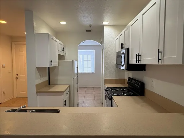 a kitchen with stainless steel appliances a refrigerator and a stove top oven