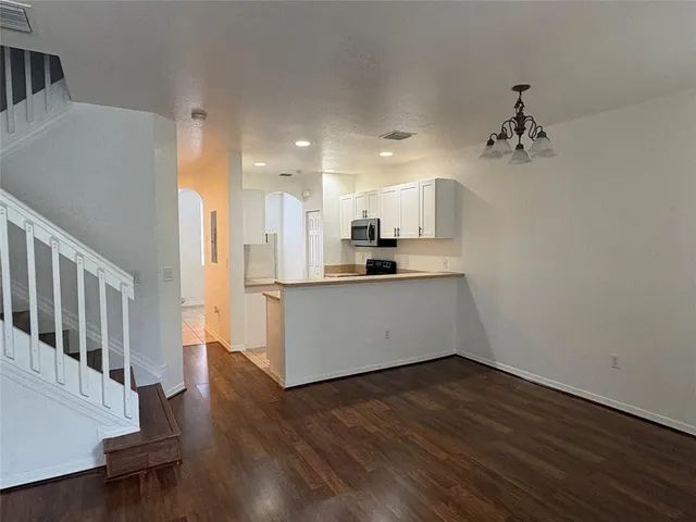 a view of a kitchen with wooden floor and electronic appliances