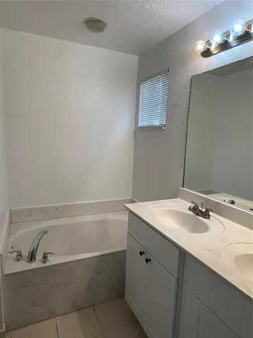 a bathroom with a sink vanity tub and shower