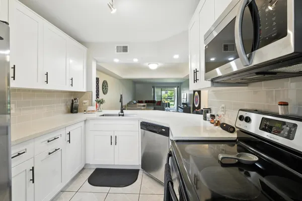 a kitchen with a sink appliances and cabinets