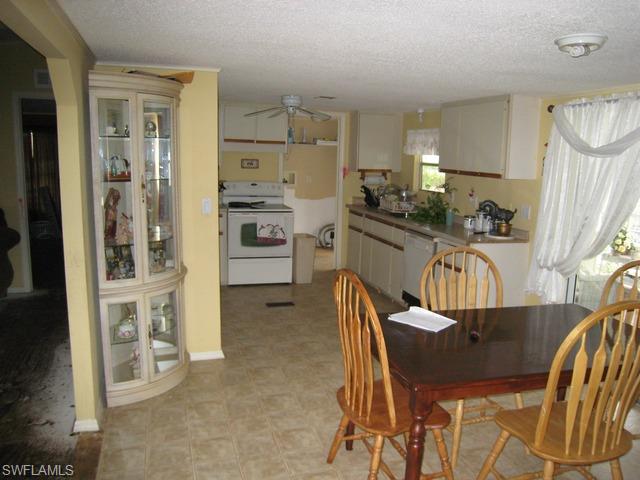 21 Ocho Rios Naples, FL 34114 - Photo 11 of 14 a kitchen with a table chairs refrigerator and microwave