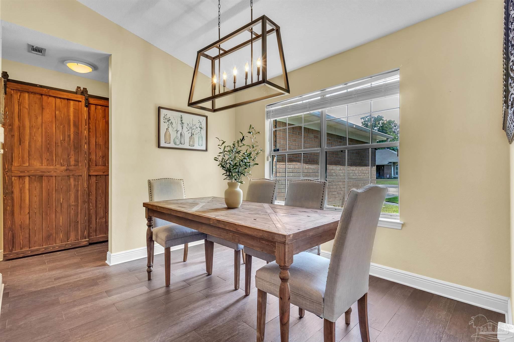 4321 Ridgeland Drive Pace, FL 32571 - Photo 5 of 36 a view of a dining room with furniture window and wooden floor