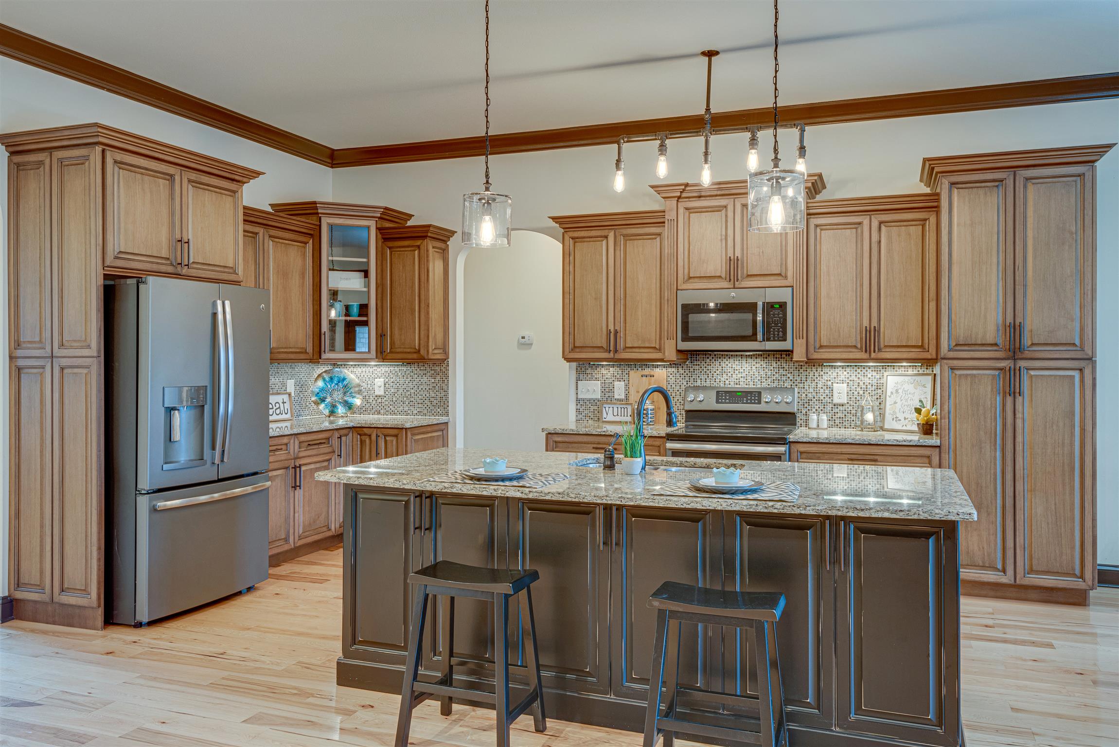 2610 Gunn Road Adams, TN 37010 - Photo 9 of 24 a kitchen with kitchen island granite countertop a refrigerator a sink dishwasher a stove and white cabinets with wooden floor